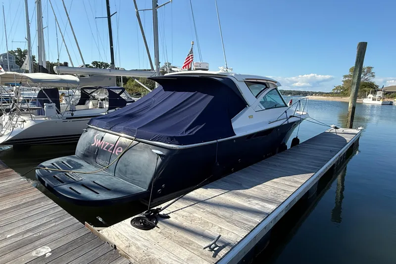  Yacht Photos Pics 2012 Tiara Yachts 3100 Coronet docked, covered, with American flag, sunny marina setting.