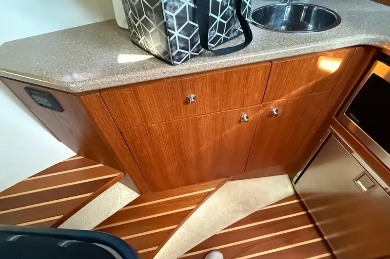  Yacht Photos Pics 2012 Tiara Yachts 3100 Coronet interior with wooden cabinetry and compact sink.