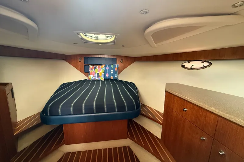  Yacht Photos Pics 2012 Tiara Yachts 3100 Coronet cabin with bed, wood cabinetry, and porthole window.