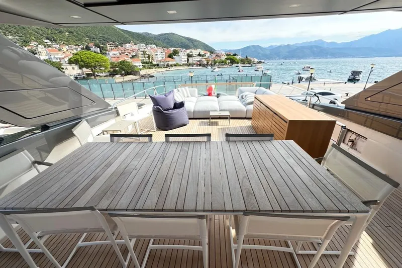 Saam II Yacht Photos Pics Luxurious 2024 Sanlorenzo SL96 yacht deck with dining area and scenic waterfront view.
