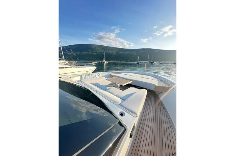 Saam II Yacht Photos Pics 2024 Sanlorenzo SL96 yacht with luxurious deck seating, docked in a scenic harbor.