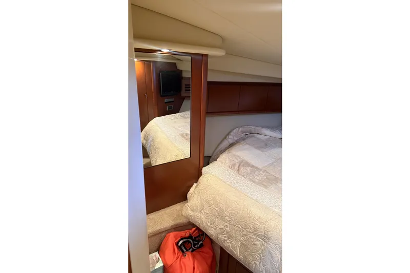  Yacht Photos Pics Interior cabin of 2007 Sea Ray Sundancer 400 with bed, mirror, and TV.