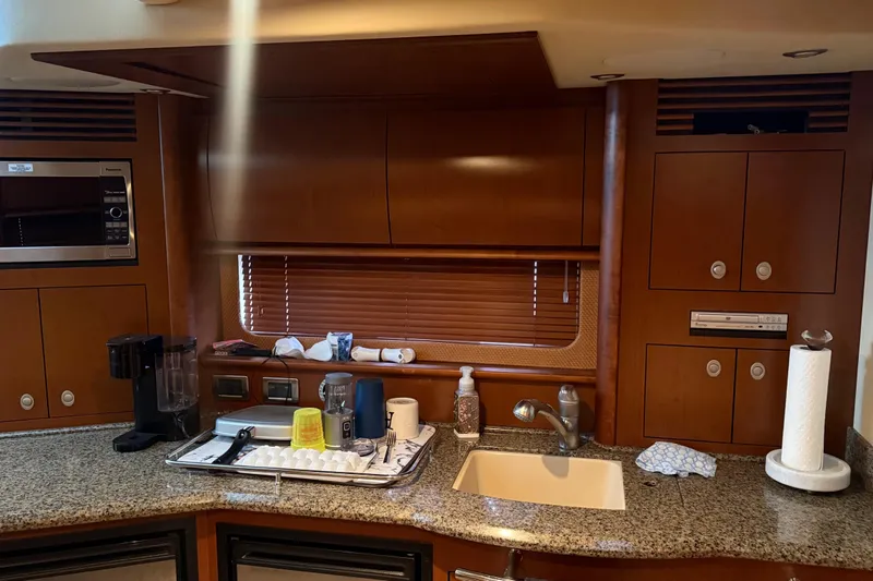  Yacht Photos Pics 2007 Sea Ray Sundancer 400 kitchen with granite countertops, sink, and wooden cabinetry.