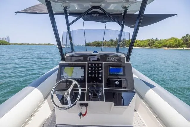  Yacht Photos Pics 2018 RIB CVL Colt 35 boat dashboard with steering wheel, controls, and navigation screens on open water.