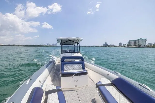  Yacht Photos Pics 2018 RIB CVL Colt 35 boat cruising on open water with city skyline in background.
