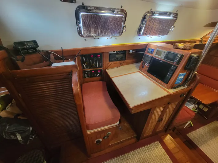 Searcher Yacht Photos Pics Navigation station inside 1981 Tayana Vancouver 42 sailboat, featuring control panels and seating.