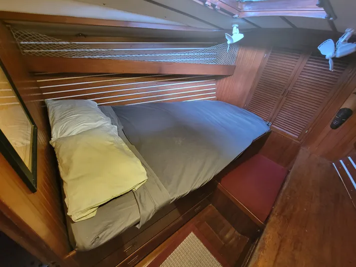 Searcher Yacht Photos Pics Cozy cabin interior of 1981 Tayana Vancouver 42 sailboat with wooden paneling and bed.