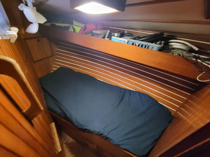 Searcher Yacht Photos Pics Cozy cabin interior of 1981 Tayana Vancouver 42 sailboat with wooden paneling and single bed.