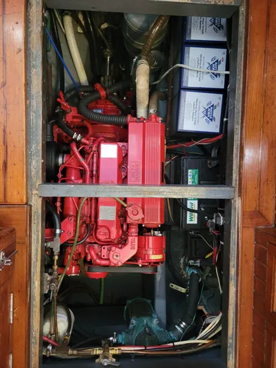 Searcher Yacht Photos Pics Engine compartment of a 1981 Tayana Vancouver 42 sailboat, featuring a red engine and batteries.