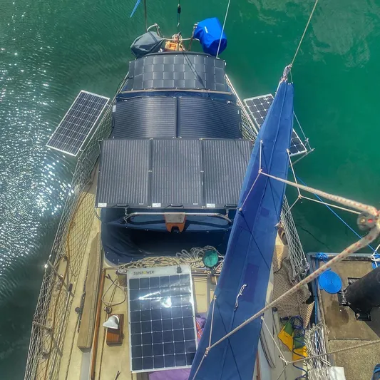 Searcher Yacht Photos Pics 1981 Tayana Vancouver 42 sailboat with solar panels on deck, docked in clear water.