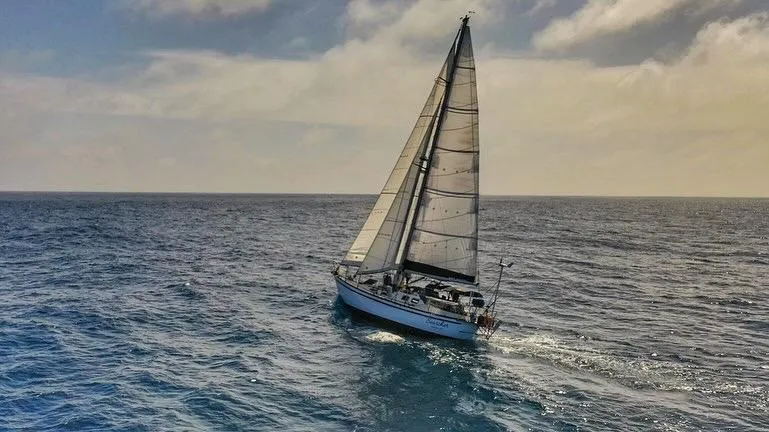 Searcher Yacht Photos Pics Sailing yacht Tayana Vancouver 42, 1981 model, cruising on open sea under a cloudy sky.