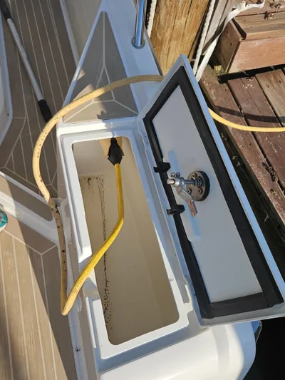  Yacht Photos Pics Open storage compartment on a 2020 Nimbus Weekender 9 boat with hose and faucet.