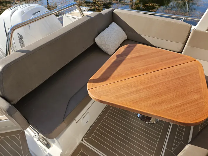  Yacht Photos Pics Cozy seating area on 2020 Nimbus Weekender 9 boat with wooden table and cushion.