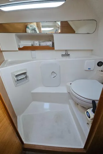  Yacht Photos Pics Compact bathroom in 2020 Nimbus Weekender 9 boat, featuring toilet and mirror.