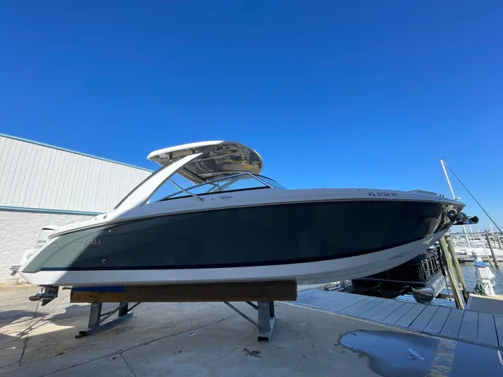  Yacht Photos Pics 2021 Cobalt 30SC Outboard boat on dock under clear blue sky.