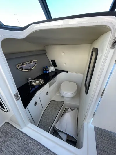  Yacht Photos Pics 2021 Cobalt 30SC Outboard boat interior with compact bathroom and sink.