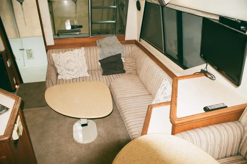 Mokikem Yacht Photos Pics Interior of 1995 Bayliner 3988 Command Bridge Motoryacht with cozy seating and table.