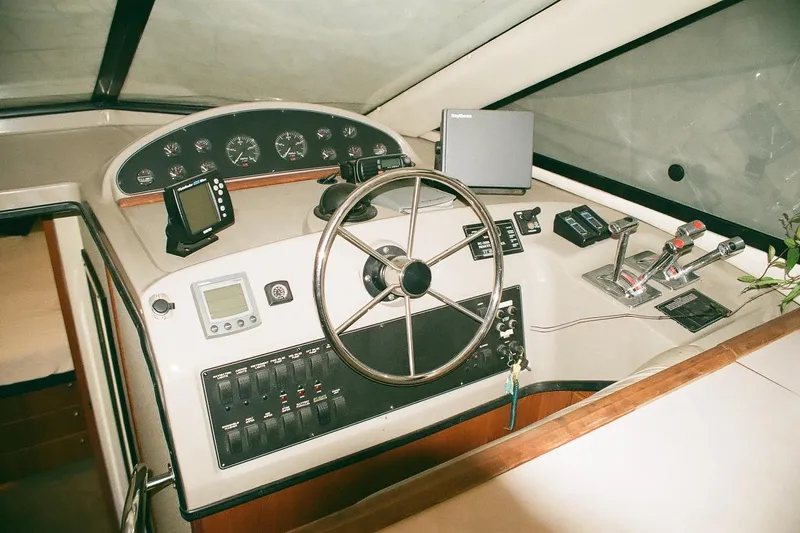 Mokikem Yacht Photos Pics 1995 Bayliner 3988 Command Bridge Motoryacht helm with steering wheel and navigation instruments.