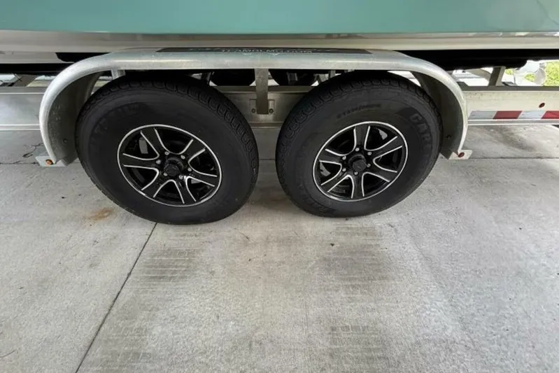  Yacht Photos Pics Trailer wheels of a 2021 Sea Fox 288 Commander boat on concrete surface.