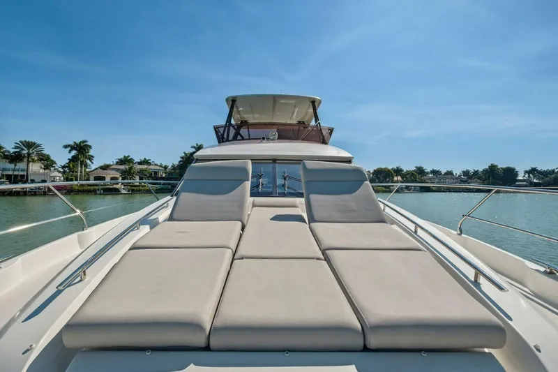 No Patience Yacht Photos Pics Luxurious 2022 Prestige 520 yacht with sunbathing deck, docked by palm-lined waterfront.