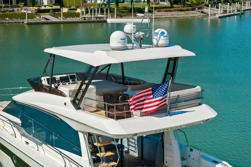 No Patience Yacht Photos Pics Luxury 2022 Prestige 520 yacht with American flag, docked in serene waters.