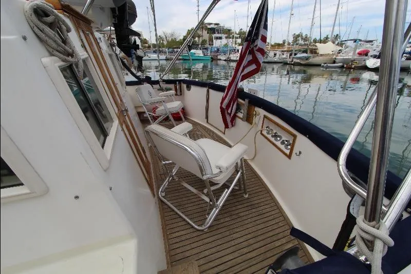  Yacht Photos Pics 1989 Grand Banks Classic yacht deck with seating, American flag, and marina view.