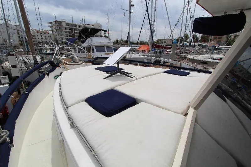  Yacht Photos Pics 1989 Grand Banks Classic yacht with cushioned deck, docked in a marina.