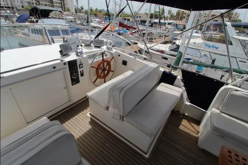  Yacht Photos Pics 1989 Grand Banks Classic yacht helm with wooden wheel and cushioned seating in marina.