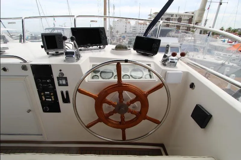  Yacht Photos Pics Helm of 1989 Grand Banks Classic yacht with wooden wheel and navigation equipment.