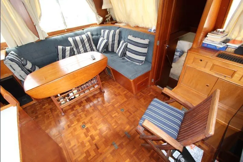  Yacht Photos Pics 1989 Grand Banks Classic yacht interior with wooden flooring, blue seating, and striped cushions.