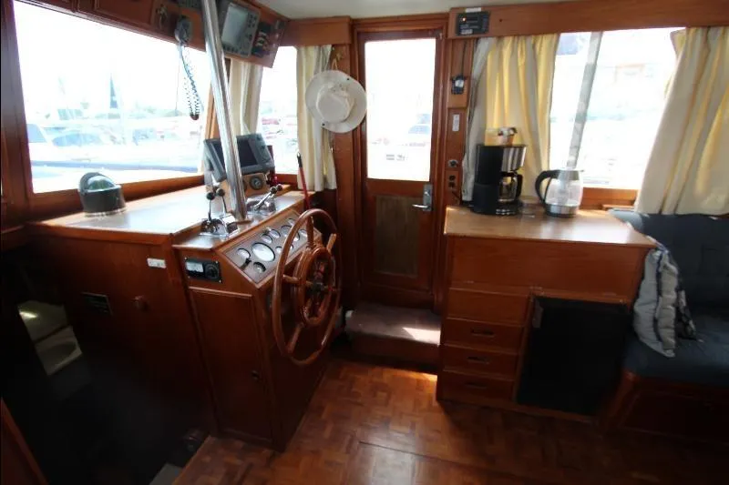  Yacht Photos Pics 1989 Grand Banks Classic boat interior with wooden helm, coffee maker, and seating area.