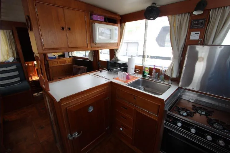  Yacht Photos Pics 1989 Grand Banks Classic yacht kitchen with wooden cabinetry, stove, and sink.