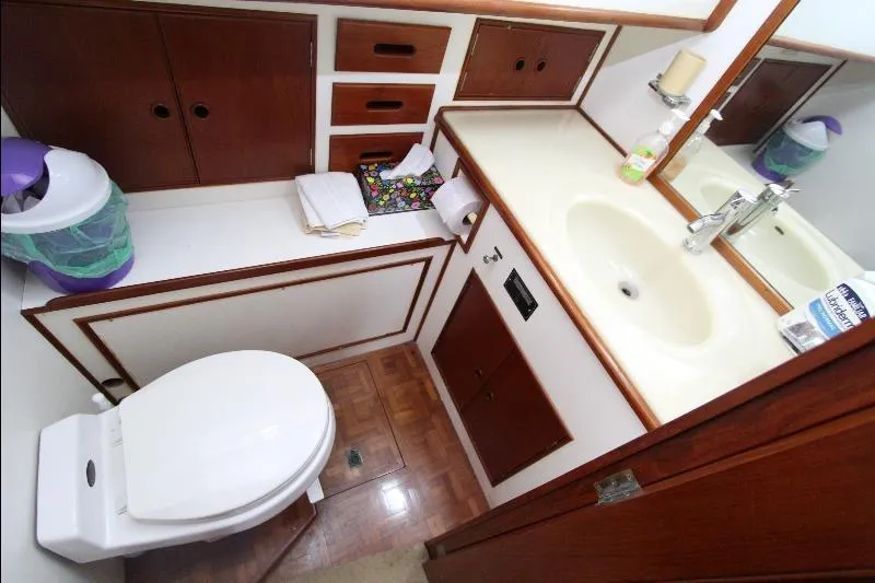  Yacht Photos Pics 1989 Grand Banks Classic yacht bathroom with sink, toilet, and wooden cabinetry.