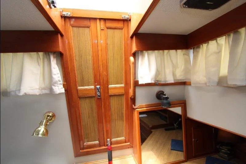  Yacht Photos Pics Interior of 1989 Grand Banks Classic boat with wooden doors and curtains.