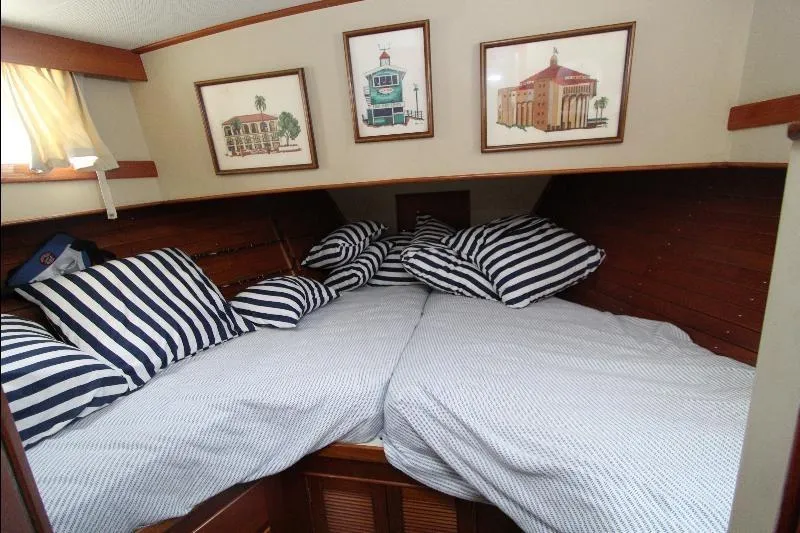  Yacht Photos Pics Cozy cabin interior of 1989 Grand Banks Classic with striped bedding and framed artwork.