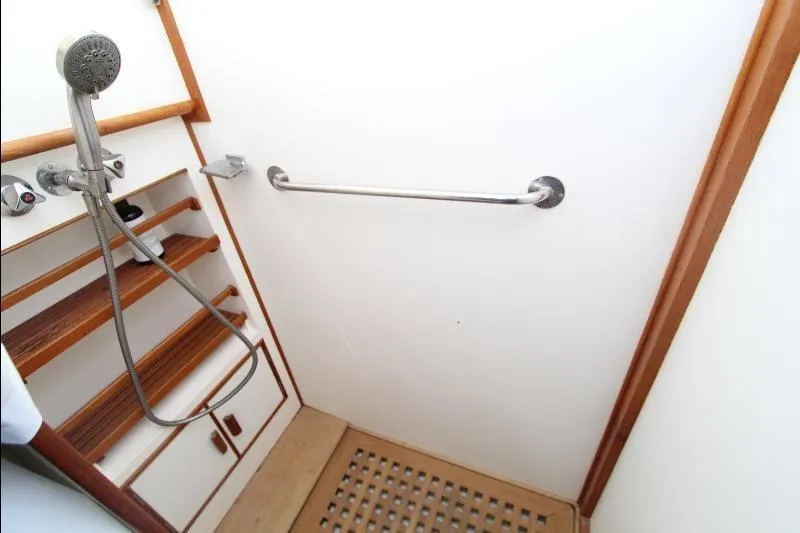  Yacht Photos Pics Shower area in 1989 Grand Banks Classic boat with wooden accents and handheld showerhead.