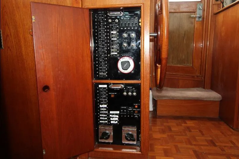  Yacht Photos Pics Electrical panel inside 1989 Grand Banks Classic boat, featuring wooden cabinetry and control switches.