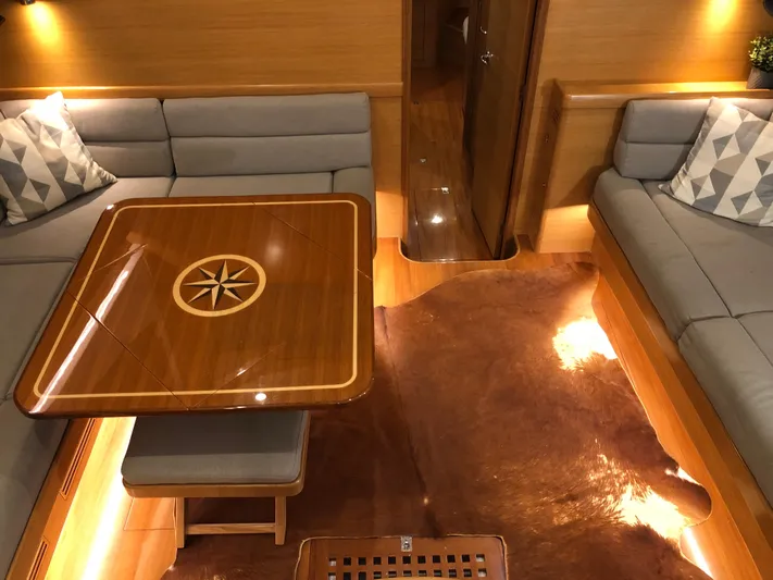 Pneumatic Yacht Photos Pics Luxurious interior of 2020 Outbound 56 yacht with elegant wood table and plush seating.