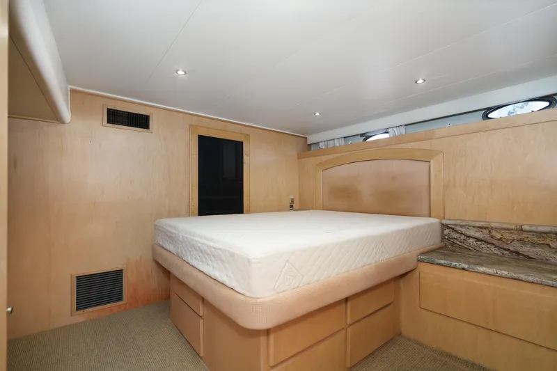 Shady Lady Yacht Photos Pics Bedroom interior of 1995 Navigator Classic yacht with wood paneling and built-in storage.