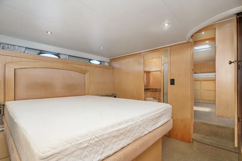Shady Lady Yacht Photos Pics Spacious bedroom interior of 1995 Navigator Classic yacht with wooden accents and cozy lighting.
