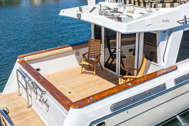 Shady Lady Yacht Photos Pics Navigator Classic 1995 yacht with wooden deck and chairs on a sunny day.