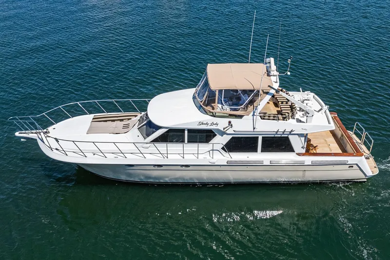 Shady Lady Yacht Photos Pics 1995 Navigator Classic yacht cruising on clear blue water, featuring a spacious deck and elegant design.
