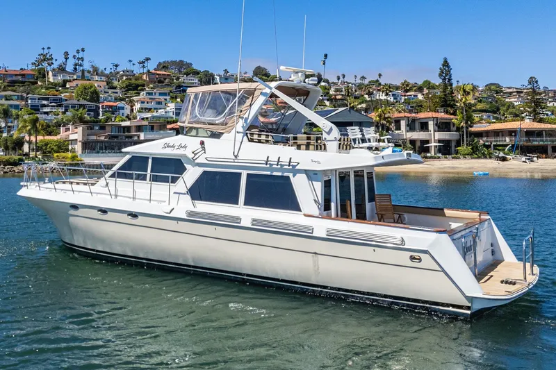 Shady Lady Yacht Photos Pics 1995 Navigator Classic yacht cruising near coastal homes on a sunny day.