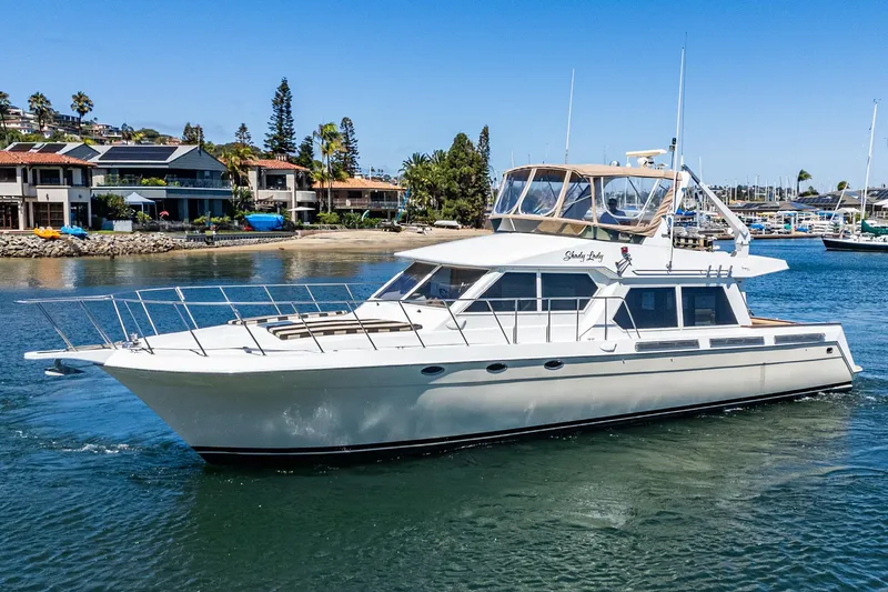 Shady Lady Yacht Photos Pics 1995 Navigator Classic yacht cruising near waterfront homes under clear blue skies.