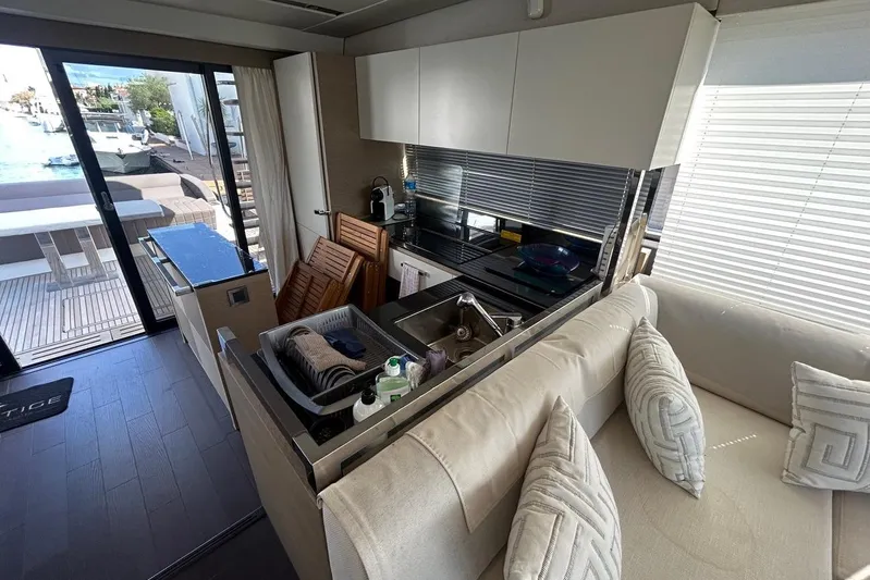  Yacht Photos Pics Modern kitchen and lounge area inside a 2018 Prestige 680S yacht, featuring sleek design and ample light.