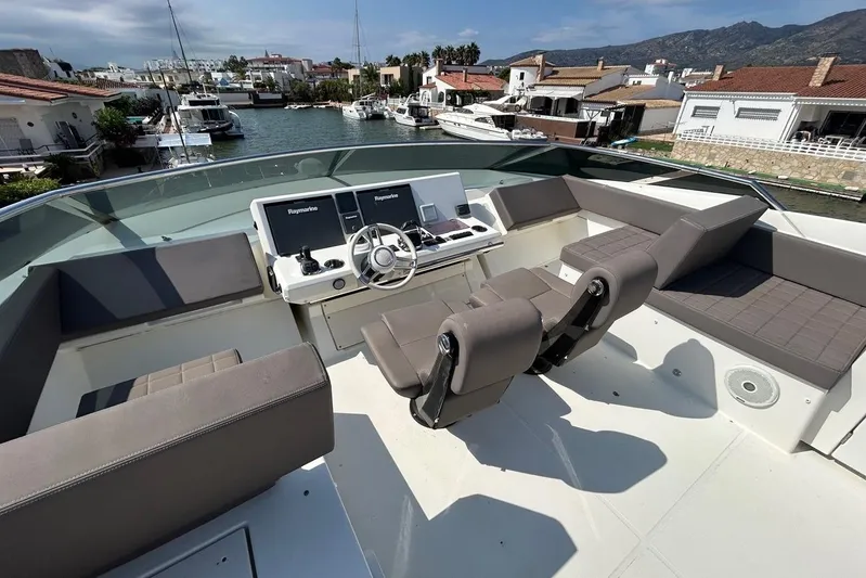 Yacht Photos Pics Flybridge of 2018 Prestige 680S yacht with modern helm and seating, docked in a marina.