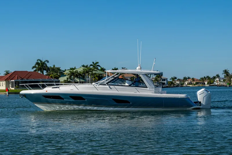 Karey Lee Yacht Photos Pics 2024 Intrepid 477 Evolution yacht cruising on a sunny day near waterfront homes.