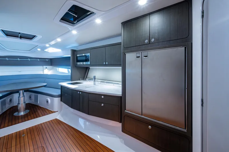 Karey Lee Yacht Photos Pics Luxurious interior of 2024 Intrepid 477 Evolution yacht with modern kitchen and seating area.