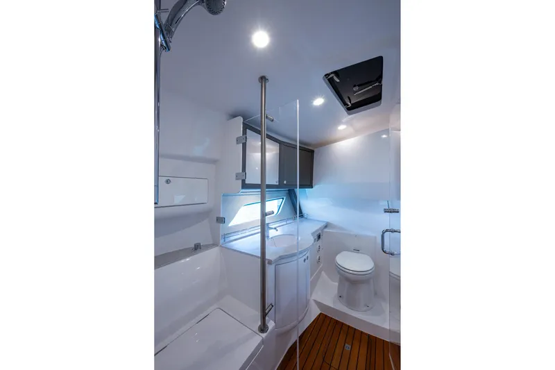 Karey Lee Yacht Photos Pics Luxurious bathroom in 2024 Intrepid 477 Evolution yacht with modern fixtures and wooden flooring.