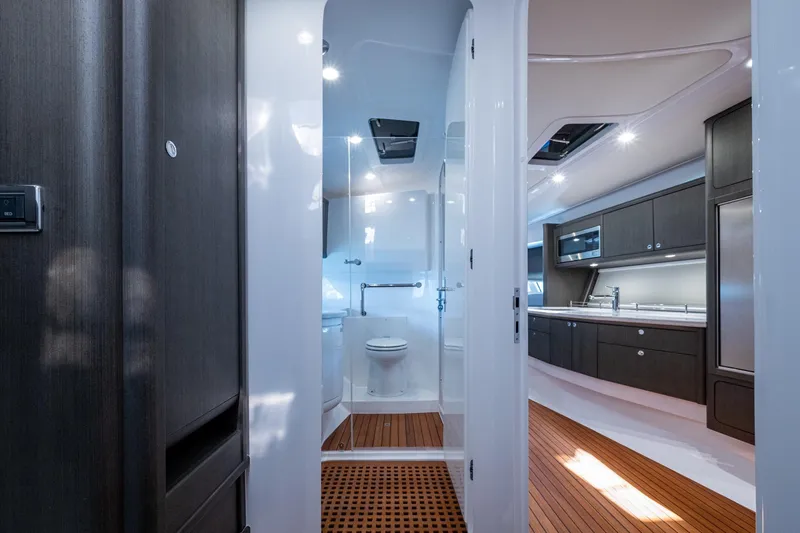 Karey Lee Yacht Photos Pics Luxurious interior of 2024 Intrepid 477 Evolution yacht, featuring modern kitchen and bathroom.